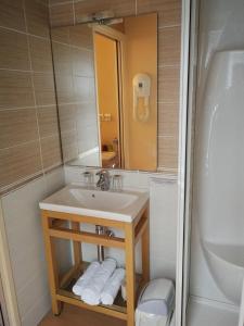 a bathroom with a sink and a mirror and a shower at Le relais de l'Argoat in Belle-Isle-en-Terre