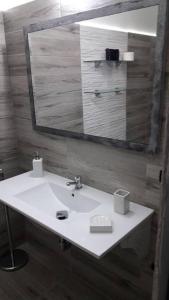 ein Badezimmer mit einem weißen Waschbecken und einem Spiegel in der Unterkunft !!!OFFERTA LAST MINUTE!!! 300m dalla spiaggia in Torre Lapillo