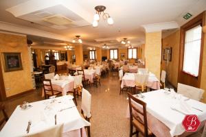 a dining room with white tables and chairs at Trattoria Bettola in Lonato