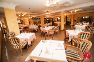 une salle à manger avec tables et chaises et nappes blanches dans l'établissement Trattoria Bettola, à Lonato