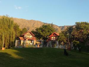 una casa sentada en la cima de un exuberante campo verde en Cabañas Dalga Inn en Merlo