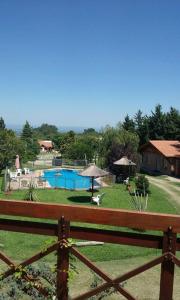 una valla frente a un patio con piscina en Cabañas Dalga Inn en Merlo
