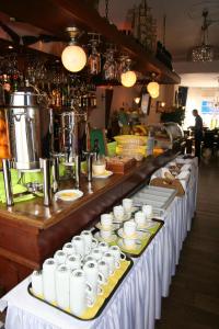 ein Buffet mit weißen Tassen und Teller mit Speisen in der Unterkunft Hotel Albion in Scheveningen
