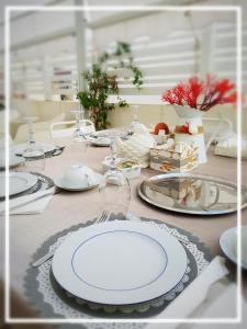 una tavola con piatti bianchi e argenteria di Donna Maria b&b a Favignana
