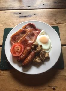 a plate of food with sausage eggs and mushrooms at The Jolly Huntsman in Chippenham