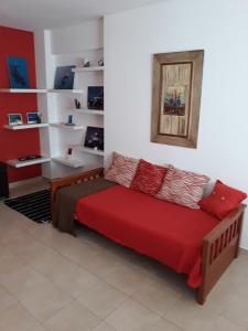 a couch in a room with a red blanket at Las Anémonas Centro in Puerto Madryn