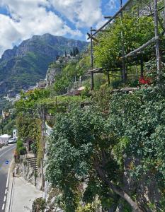 una calle con árboles y arbustos al lado de una montaña en Casetta Arienzo, en Positano