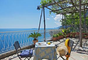 un tavolo e sedie su un balcone con vista sull'oceano di Casetta Arienzo a Positano