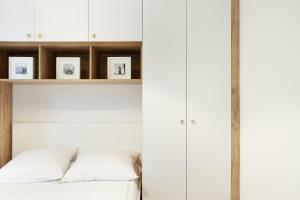 a bedroom with white cabinets and a bed at Sea Point Apartment - Hav Aparts in Gdańsk
