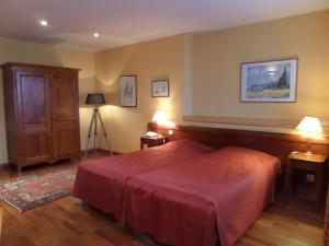 1 dormitorio con 1 cama con manta roja en Hôtel Restaurant Erckmann Chatrian, en Phalsbourg