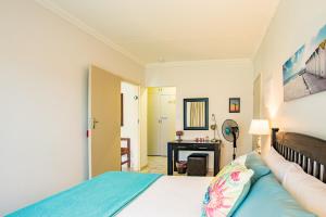 a bedroom with a bed and a desk in a room at LeoZet Self catering apartment in Pretoria