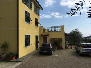 a yellow building with two cars parked in front of it at Le Fiabe in Sestri Levante