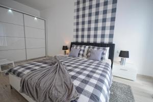 a bedroom with a black and white checkered bed at Apartament nad Drwęcą I in Ostróda