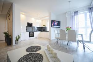 a kitchen and living room with a table and chairs at Apartament nad Drwęcą I in Ostróda