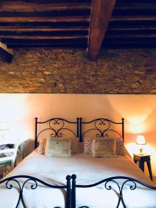 a bed in a bedroom with a stone wall at The Lazy Olive Villa - Podere Finerri in Asciano +112 photos