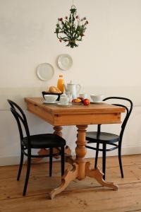 einen Tisch mit zwei Stühlen und eine Schale Obst darauf in der Unterkunft SCHÖNER WOHNEN IM DENKMAL - großzügig geschnitten, kostenfreies WLAN in Leipzig