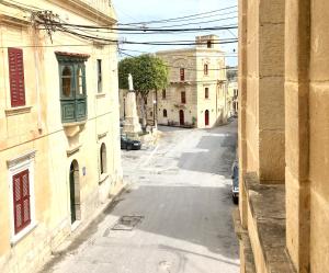 an empty street in an alley between two buildings at Xemx in Qala