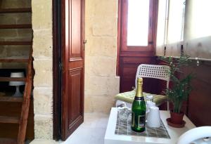 a bottle of champagne on a table with a chair at Xemx in Qala