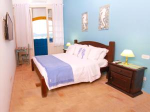 a bedroom with a bed and a table with a lamp at Pousada do Cais in Paraty