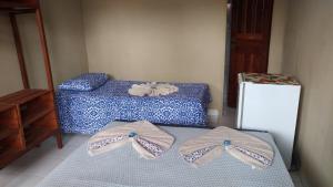 two pairs of shoes sitting on a bed in a room at Pousada Vila Alter in Alter do Chao