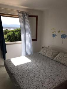 a bedroom with a bed and a large window at Giulianahouse in La Maddalena