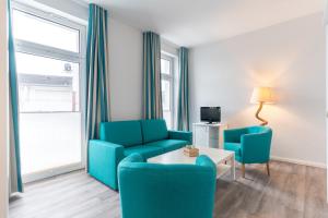 a living room with two chairs and a couch and a table at Ria‘s Beachhouse in Borkum