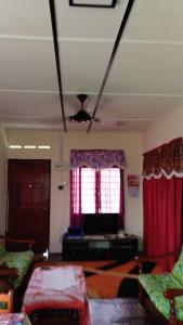 een woonkamer met rode gordijnen en een televisie bij LOT7040 in Melaka