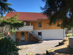 a house with a garage and a white fence at La remise du Murgé in Saulxures-sur-Moselotte