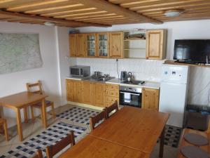 a kitchen with wooden cabinets and a wooden table and a table and chairs at Zubrovica in Telgárt