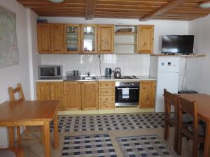 a kitchen with wooden cabinets and a sink and a table at Zubrovica in Telgárt