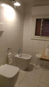 a bathroom with a toilet and a tub and a sink at Terrazze Fiorite in Bergamo