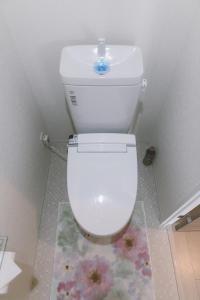 - białą toaletę w łazience z dywanem kwiatowym w obiekcie Crystal Exe Nipponbashi w Osace