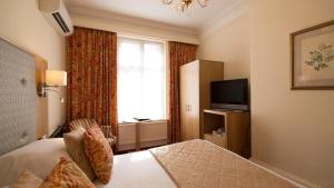 Телевизор и/или развлекательный центр в Langstone Cliff Hotel