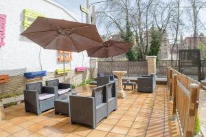 d'une terrasse avec des tables, des chaises et un parasol. dans l'établissement Hostal Los Calatravos, à Alcañiz
