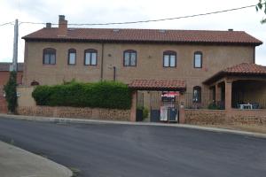 a large brick house on the side of a street at Hotel Rural Casa El Cura in Calzadilla de los Hermanillos
