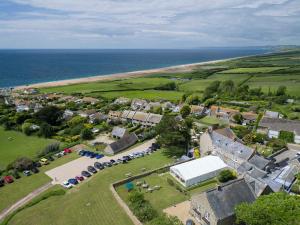 an aerial view of a village with a tent and the ocean at The Manor House in Puncknowle