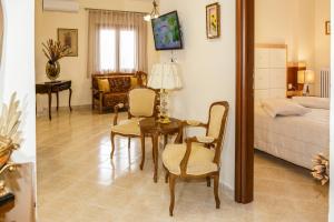 Una sala de estar con una cama, una mesa y sillas. en House Maria, en Agios Nikolaos