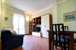a living room with a couch and a table and a television at Maison Bury in Rapolano Terme