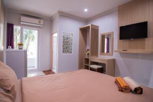 1 dormitorio con 1 cama y TV de pantalla plana en TN Thanyawit, en Nakhon Ratchasima