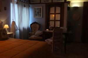 een slaapkamer met een bed, een bureau en een raam bij B&B The Roses Garden in Millesimo