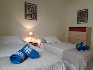 twee bedden in een slaapkamer met blauwe kussens erop bij ANDALUCIA 57 in Estepona