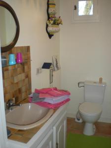 uma casa de banho com um lavatório e um WC em Chez Annick em Guérande