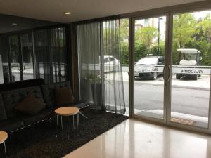 a lobby with glass doors and tables and a street at Dcondo Kathu Patong Phuket by Suna in Kathu