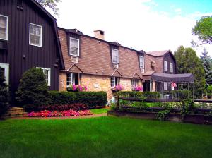 una casa grande con un patio con césped verde y flores en Old Field House, en North Conway