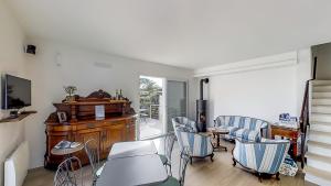 a living room with chairs and a table and a television at B&B Bessy 10 in Antibes