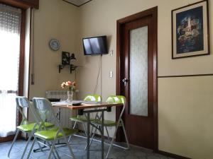 a dining room with a table and green chairs at Appartamento in Riviera Ligure in Borghetto Santo Spirito