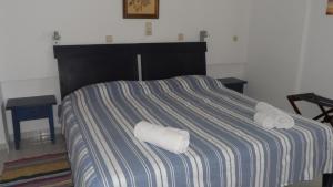 a bed with two rolled towels on top of it at Villa Giorgos in Kefalos
