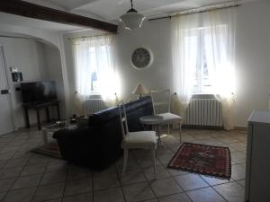 a living room with a couch and chairs and windows at B & B Abbadia in Monesiglio