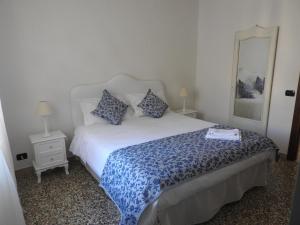 een slaapkamer met een bed met een blauw en wit dekbed bij B & B Abbadia in Monesiglio