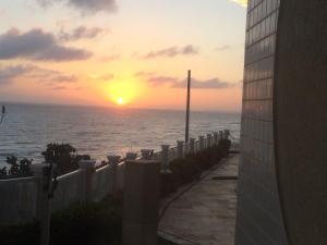 einen Sonnenuntergang über dem Meer von einem Gebäude in der Unterkunft Apart Canoa Quebrada in Canoa Quebrada